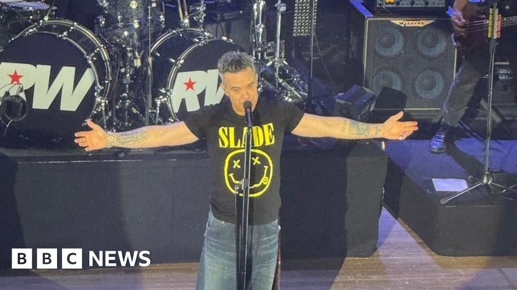 Fan who gave Robbie Williams number as teen joins him on stage